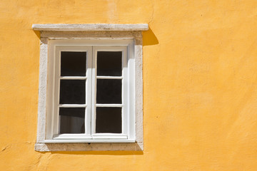 Fototapeta na wymiar Typical portuguese window against a colored plaster wall
