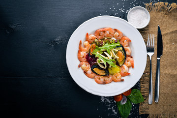 Seafood salad, mussels, shrimp, squid, and fresh vegetables. Free space for your text. Top view.