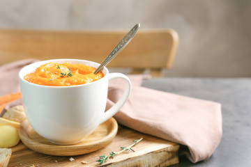 Delicious carrot soup on table