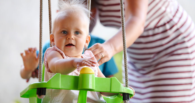 Beautiful Baby swinging outdoor with caring faimly