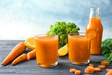 Glasses of homemade carrot juice with vegetables on dark wooden table