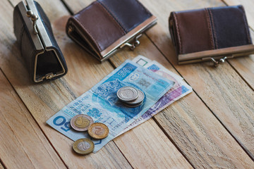 Polish zloty with a little wallet on the old wooden background