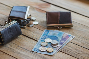 Polish zloty with a little wallet on the old wooden background