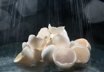 A lot of eggshells on a black background under water drops