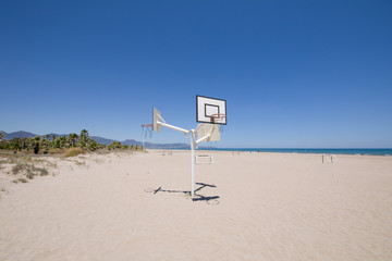 Naklejka premium basketball and soccer courts on sand at Beach of PIne or Pinar, in Grao of Castellon, Valencia, Spain, Europe. Blue clear sky, Mediterranean Sea and Benicassim in the horizon 