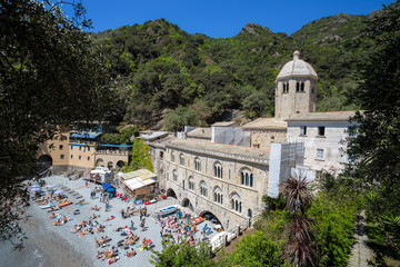 Naklejka premium SAN FRUTTUSO DI CAMOGLI, ITALY, MAY, 4, 2016 - San Fruttuoso di Camogli, Ligurian coast, Genoa province, with its ancient Abbaey, the beach and tourists.