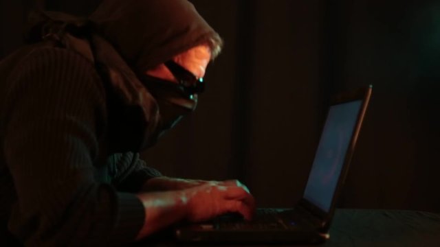 Ein anonym maskierter Mann am Laptop macht Cybercrime als Kriminalfilm