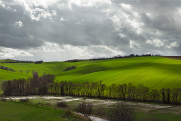 Natural landscape in a spring day, green fields and cloudy sky