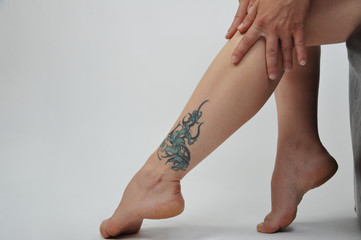 Frauenbeine Füße Heels tattoo eincremen