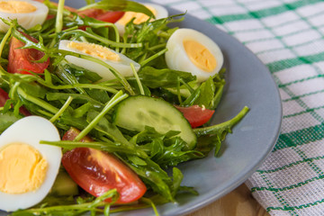 Fresh green salad with arugula, tomatoes, eggs and cucumber