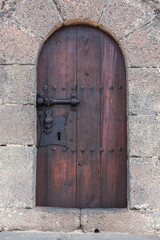 Old wooden door with metal decoration on the stone wall,  Lanzarote, Canary Islands, Spain