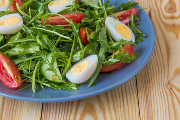 Fresh green salad with arugula, tomatoes, eggs and cucumber