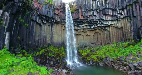 Aerial footage of the Svartifoss waterfall emptying into a small river.