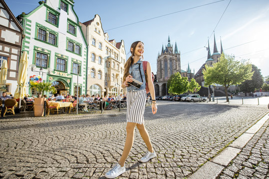 Portrait of a young woman tourist traveling with photo camera in the old town of Erfurt city, Germany