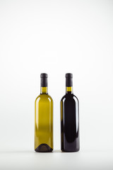 close-up view of two wine bottles full of red and white wine isolated on white