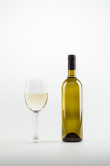 close-up view of white wine in glass and bottle isolated on white