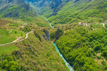 Fototapeta na wymiar Road bridge over a river in the mountains, top view