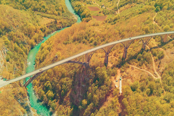 Road bridge over a river in the autumn mountains, top view