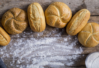 Variety of bread loaves on a white wooden table.