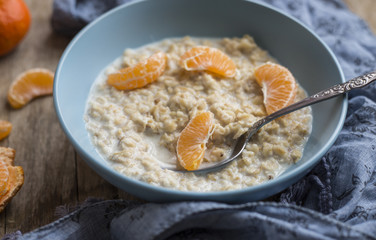 Healthy breakfast - oatmeal with slices of tangerines