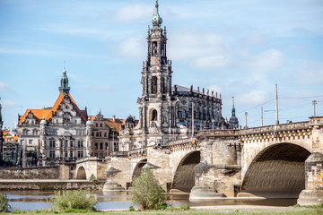 Fototapeta na wymiar View on the riverside of Elbe river with catholic church, city gates and bridge during the sunny weather in Dresden city, Germany