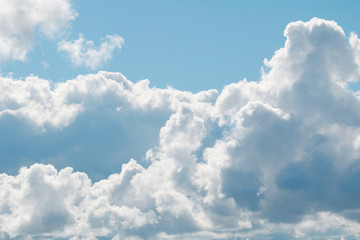 A blue sky with beautiful large fluffy clouds on a sunny and clear day.