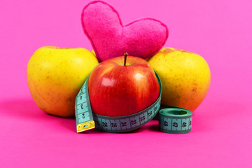 Apples and heart composition wrapped with twisted measuring tape