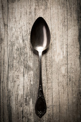 Old spoon on  wooden background.