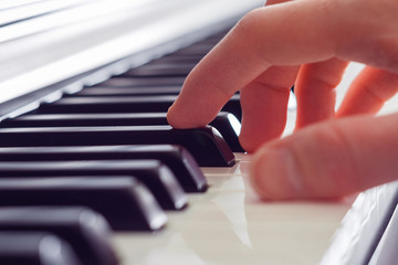 Right hand playing the piano (closeup)