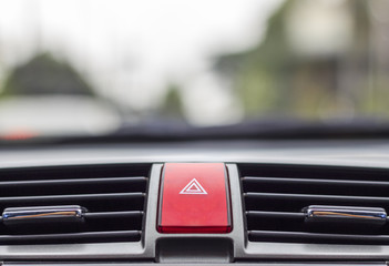 closeup car emergency light button with soft-focus and over light in the background