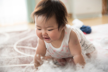 Fototapeta premium ドライアイスの白い煙で遊ぶ赤ちゃん