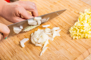 Cook cuts onions with a knife