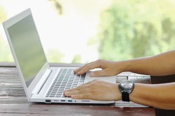 Fototapeta premium Stock photo :.Closeup image of a hands working and typing on laptop keyboard with blur nature background