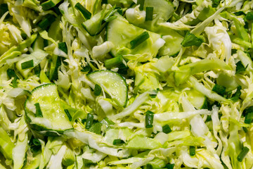 Spring vegan salad with cabbage, cucumber, green onion and parsley closeup