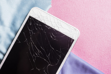 Broken mobile phone screen on a pink background