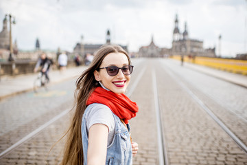 Obraz premium Lifestyle portrait of a business woman walking the bridge in the old town of Dresden, Germany