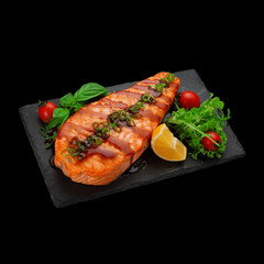 Japanese cuisine.Salmom fillet stake on a stone plate Japanese cuisine. Tempura sushi roll over dark background.