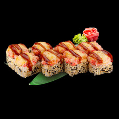 Japanese cuisine. Sushi roll with salmon and spice sauce over dark background.