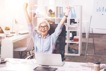 Dedicated hardworking woman cheering at her workplace