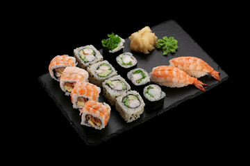 Japanese cuisine.Sushi set on a stone plate over dark concrete background.