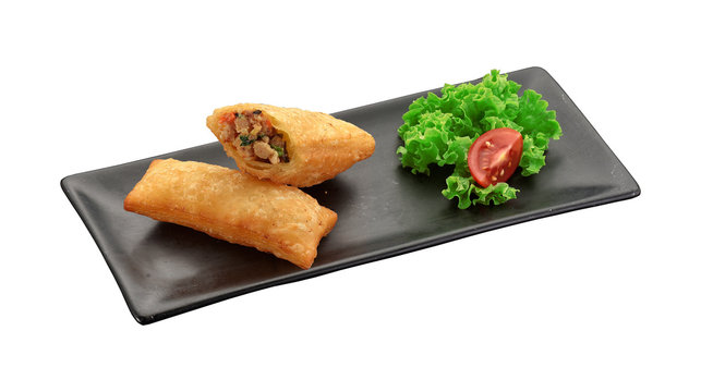 Spring roll on a black plate isolated on white background