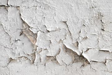 Paint peeling from dirty white exterior wall