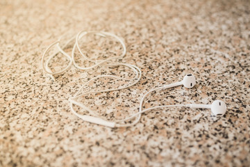 White vacuum headphones on a granite background. Horizontal frame