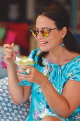 Beautiful woman  eating dessert at an outdoor restaurant, selective focus