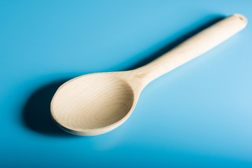 Empty Wood Spoon in blue background