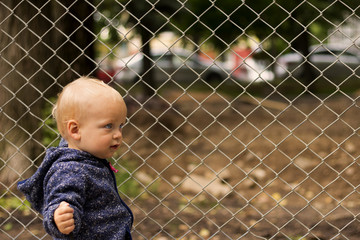 Portrait of cute toddler against of the lattice. Concept of freedom