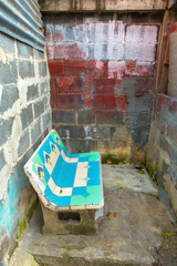 Fototapeta na wymiar Old cement chair in a brick room