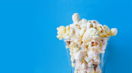 Popcorn in the glass on a blue background