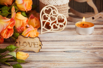 Obraz na płótnie Canvas Fresh orange roses flowers, heart, decor bottle and lit candle