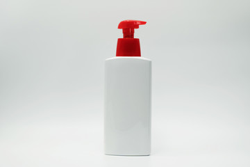 Cosmetic bottle with red pump isolated on white background